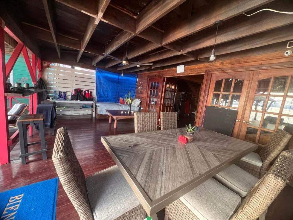 The long table under the open beams, with the kitchen doors beyond and life jackets racked against the far wall.