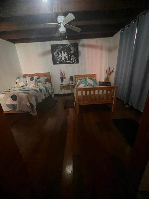 The Twin Room's two beds seen from the doorway, with a ceiling fan overhead and a table between them.