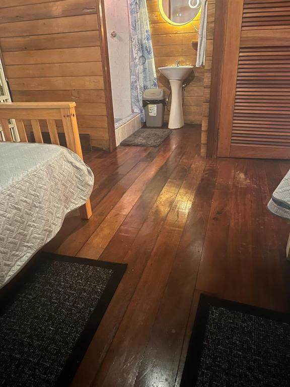 The Twin Room looking towards the shower room, across a wide plank floor with rugs beside each bed.